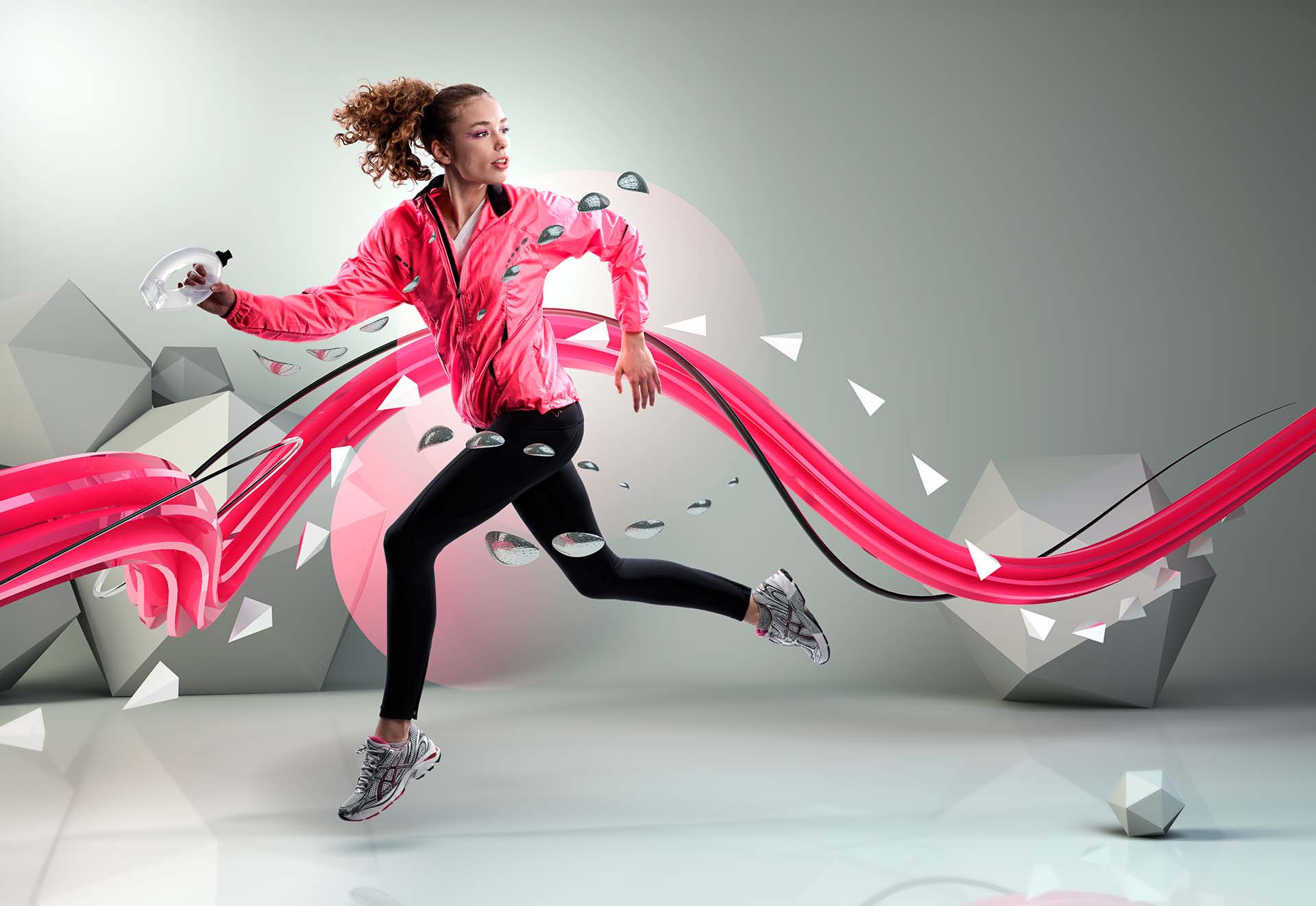 A woman runs forward, one arm out, shapes and ribbons around.